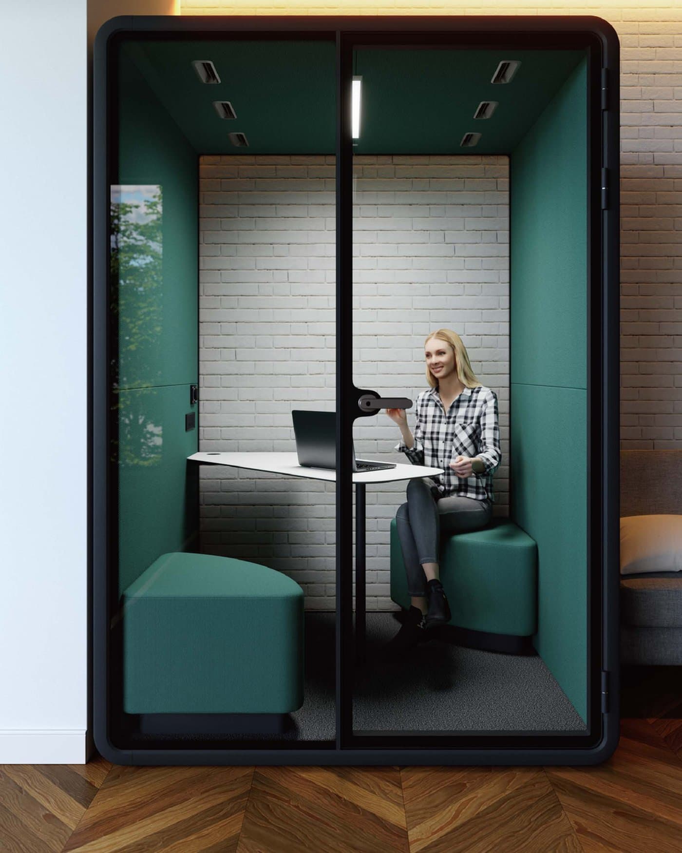 A person working on a laptop inside a teal acoustic work booth