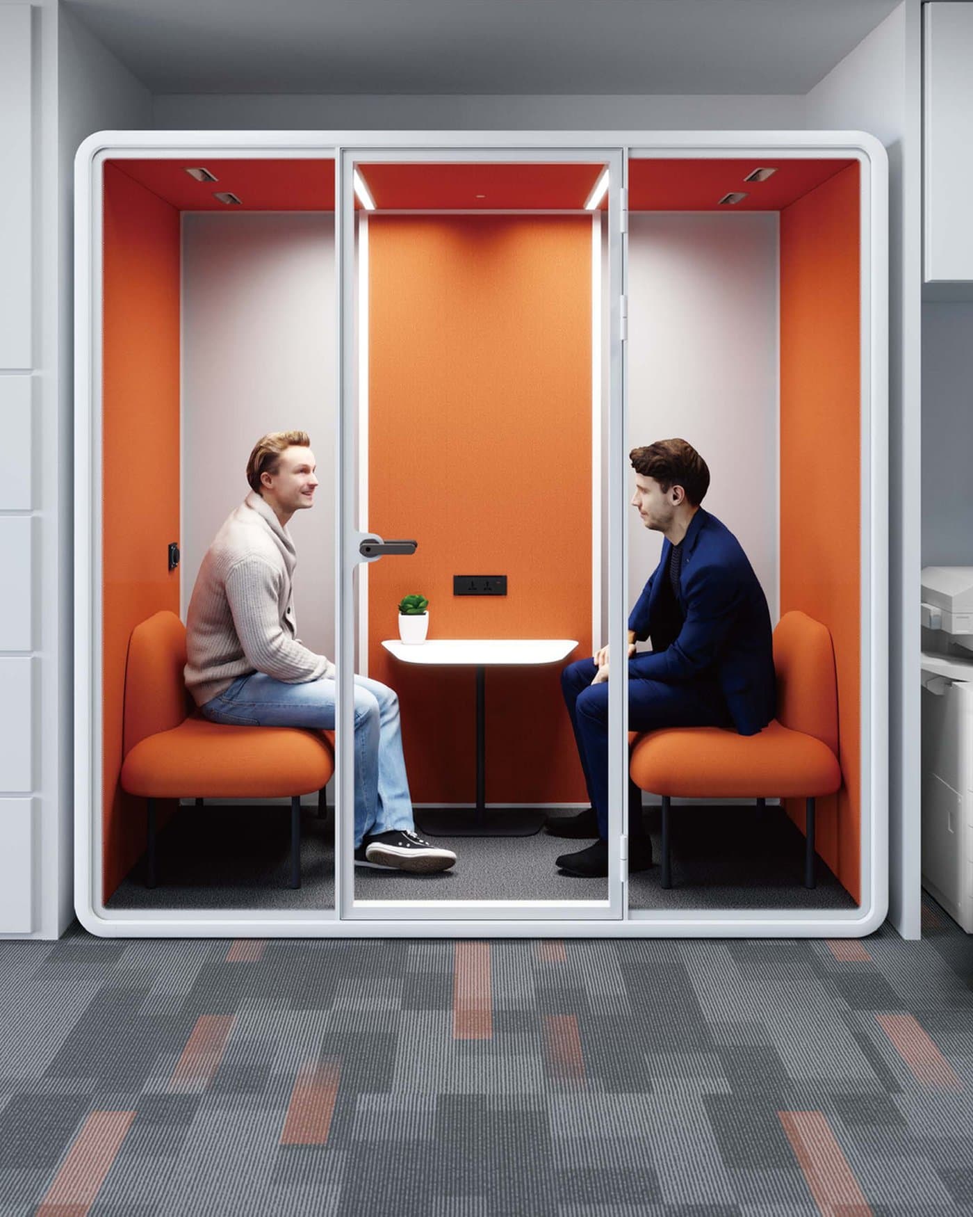 Two colleagues meeting inside an orange acoustic meeting pod